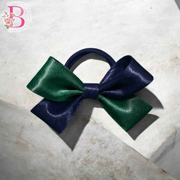 Navy blue and emerald green satin hair bow with elastic band, handcrafted boutique ponytail accessory for girls and school wear.