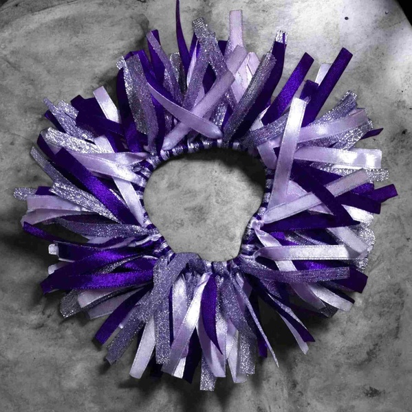 Purple and lilac glitter ribbon scrunchie with layered satin strands on a grey marble background, handmade cheer and dance hair accessory.
