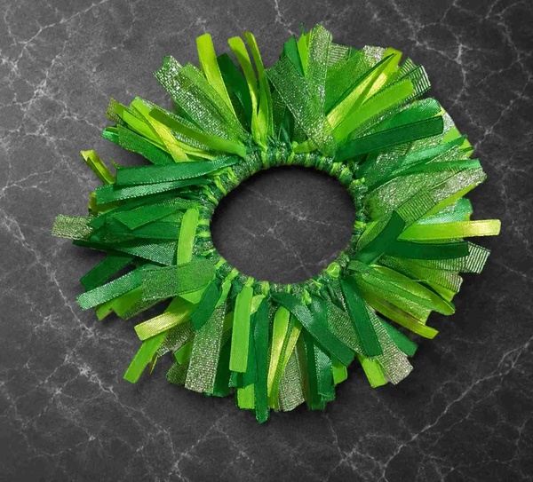 Lime glitter green ribbon fringe scrunchie hair tie on dark marble background with layered satin and mesh strips in bright lime and glitter tones.