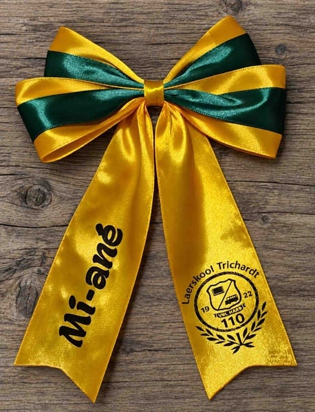 Girl viewed from behind wearing a yellow and green custom printed school hair bow with personalized name and school logo design.