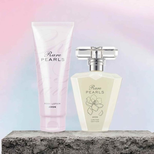 Avon Rare Pearls fragrance and matching body lotion displayed on a stone surface with a soft pastel background, elegant and feminine.