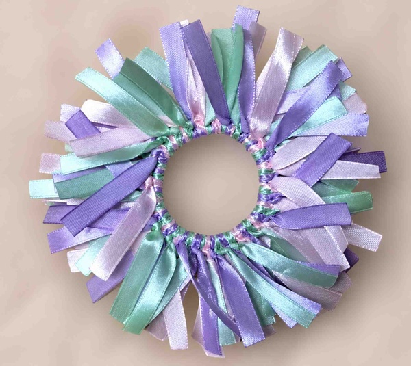 Pastel ribbon scrunchie handmade with lavender, lilac, mint, and aqua satin ribbons, displayed on a soft neutral background.