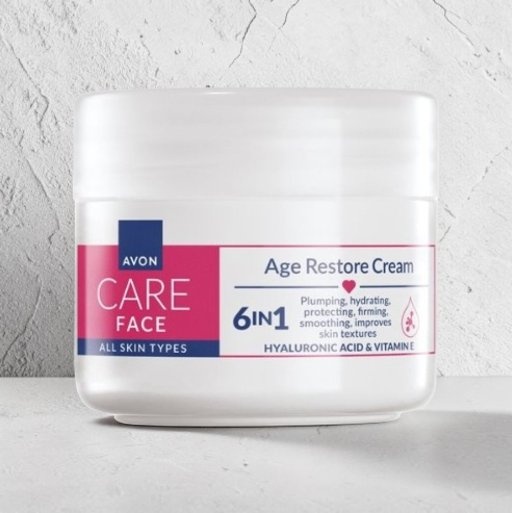 Avon Care Face Age Restore Cream in a white jar on a light textured background, featuring a 6-in-1 formula with hyaluronic acid and vitamin E.