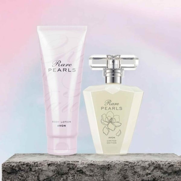 Avon Rare Pearls fragrance and matching body lotion displayed on a stone surface with a soft pastel background, elegant and feminine.
