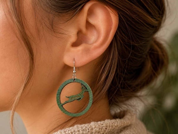 SA Springbok Rugby green hoop earrings with springbok design worn on ear, handmade with hypoallergenic hooks, close-up lifestyle photo.