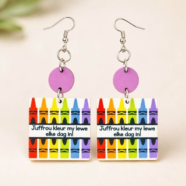 Handmade dangling teacher earrings with rainbow crayon design and Afrikaans message “Juffrou kleur my lewe elke dag in!” with hooks.