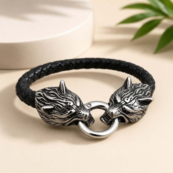 Black braided leather wolf head bracelet displayed on a soft beige background with elegant lighting for a premium product presentation.