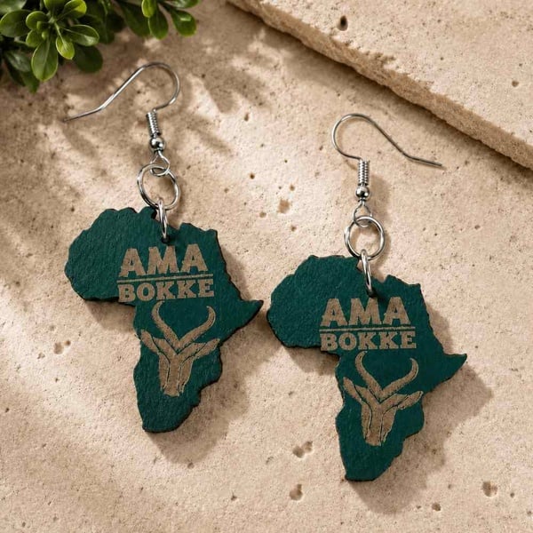 Handcrafted green Africa map AMA BOKKE wooden earrings with silver hooks on a warm stone background, rustic South African design.