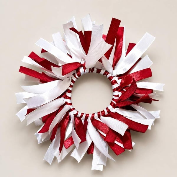 Maroon and white handmade ribbon scrunchie on a soft neutral background, showcasing satin texture and elastic design for girls' hair.