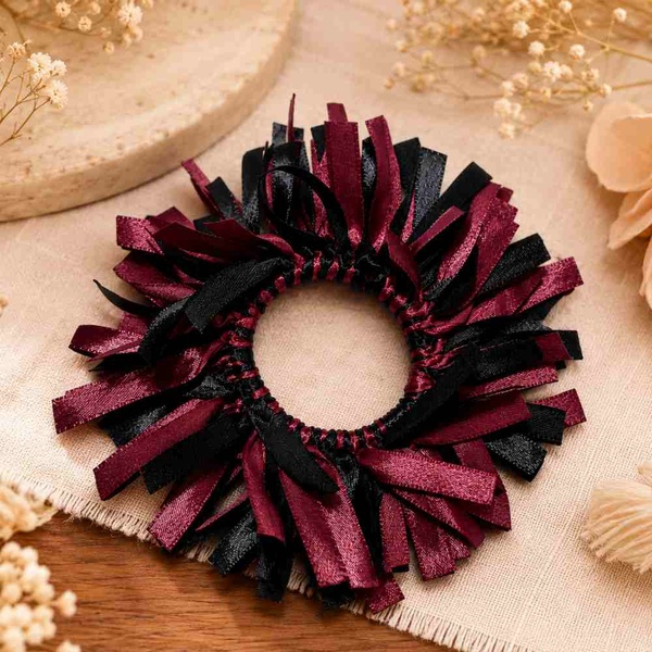 Maroon and black satin ribbon scrunchie on a warm linen and wood background, beautifully styled for premium hair accessory display.